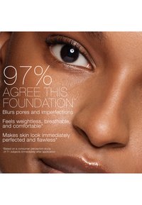 Gros plan sur un visage à la peau foncée à la texture lisse, mettant en valeur un œil clair et des lèvres, accompagné d'un texte promouvant un fond de teint qui floute les pores et offre une sensation de légèreté.