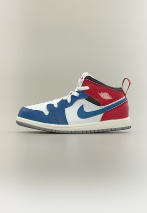 Basket montante Nike Air Jordan en rouge, blanc et bleu avec des lacets blancs et une semelle grise, vue de profil sur un fond neutre.