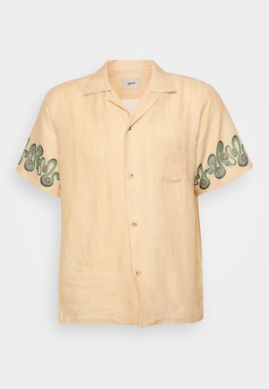 Korte mouwen, lichtbeige shirt met een zak; voorzien van groene spiraalborduursels op de mouwen; gemaakt van linnen stof met een gladde textuur.