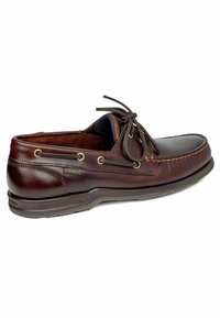 Zapato de barco de cuero marrón que presenta una punta redondeada, diseño con cordones, costuras visibles y suela de goma con un acabado texturizado.