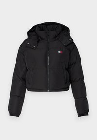 Giacca a vento nera corta con cappuccio, chiusura frontale con zip, tasche laterali e piccolo logo Tommy Jeans sul petto.