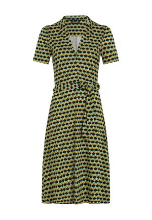 Sukienka z krótkim rękawem w heksagonalny wzór w kolorach zielonym, żółtym i czarnym. Kopertowy fason z paskiem w talii i dekoltem w serek.