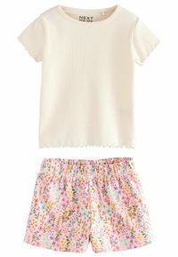 Weißes, kurzärmeliges Oberteil mit Rippstruktur und gewellten Kanten, kombiniert mit rosa, blumenbedruckten Shorts mit elastischem Bund und strukturierter Oberfläche.