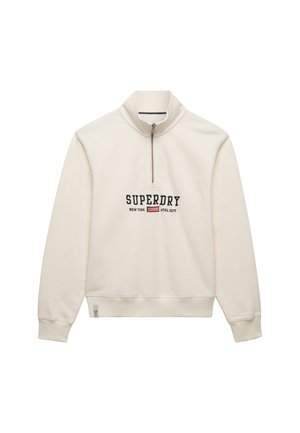 Ecru bluza z zamkiem do ćwiartki, z napisem „SUPERDRY NEW YORK ATHL DEPT” i małym logo flagi na piersi, z prążkowanymi ściągaczami przy rękawach i u dołu.