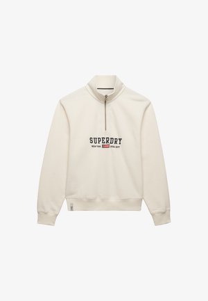 Sudadera de color blanco roto con cremallera hasta el pecho y texto "SUPERDRY NEW YORK ATHL DEPT" junto con un pequeño logo de bandera en el pecho, con puños y borde acanalados.