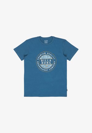 Camiseta azul de manga corta con un logo redondo de Billabong en el centro que presenta hojas tropicales y el texto "Premium Quality Boardshort Company".