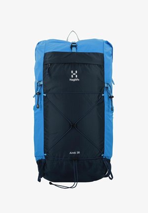 Blauwe en donkerblauwe rugzak met een groot hoofdcompartiment, extern bungee-systeem en een handvat aan de bovenkant. Heeft een klein voorvak en een logo.