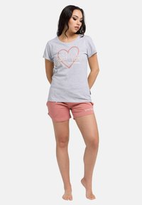 Grå bomulds-t-shirt med "Good Vibes" grafik i pink, parret med pink shorts med logo-print, afslappet pasform og korte ærmer.
