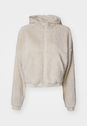 Kremfarget, kort fleece hettegenser med frontglidelås, side lommer, ribbestrikkede mansjetter og et mykt, strukturert stoff.