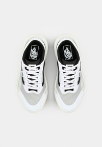 Białe i szare sneakersy z czarnymi akcentami i sznurowadłami, z logo Vans na języku i boku, przedstawione z góry na białym tle.