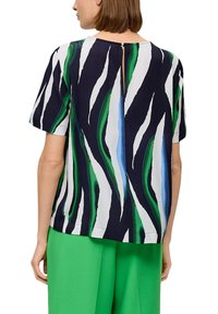 T-shirt à manches courtes avec un motif rayé coloré dans des teintes marine, verte et blanche. Présente une fente dans le dos et une coupe décontractée.