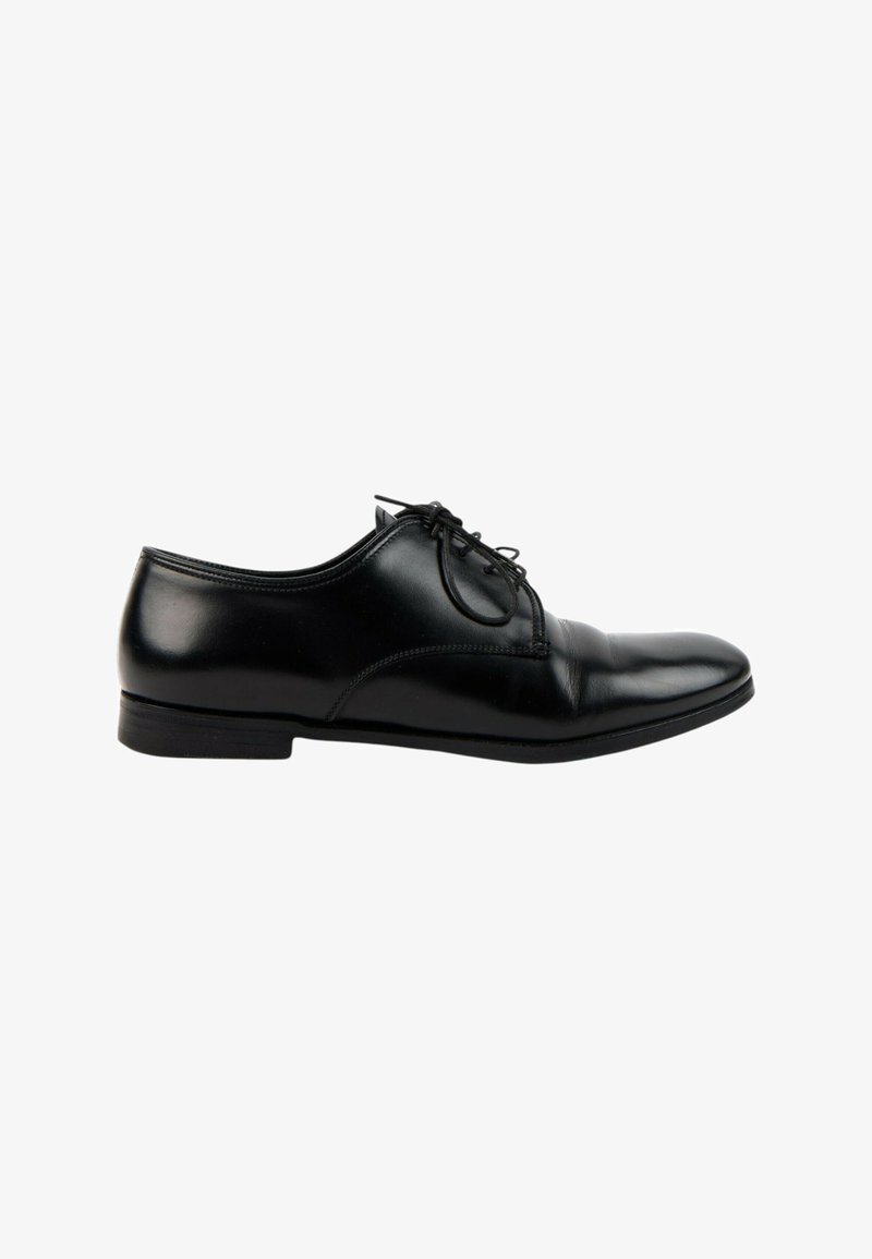 Chaussure Oxford formelle pour homme en cuir noir avec lacets, talon bas et finition lisse et polie, vue de côté sur fond blanc.