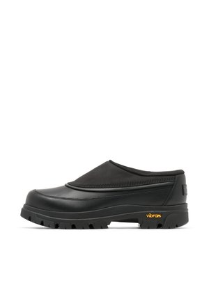 Schwarzer Slip-On-Clog mit dicker, profillierter Sohle und Vibram-Logo an der Ferse, entwickelt für den Außenbereich und den Freizeitgebrauch.