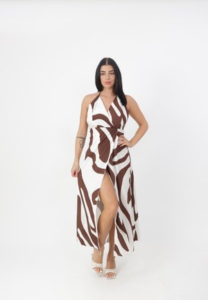 Robe maxi à col halter en marron et blanc avec un design enveloppant et une fente sur le côté. Tissu lisse avec un motif abstrait. Ajustée à la taille.
