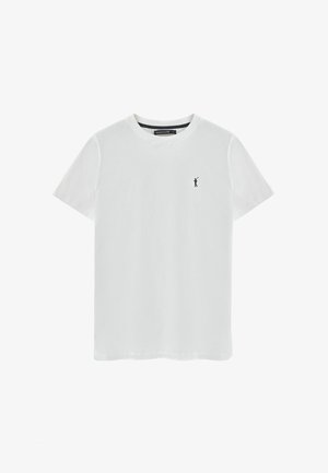 Camiseta de algodón blanca con escote en pico clásico, mangas cortas y un pequeño logo negro en el lado izquierdo del pecho. Textura suave, ajuste relajado.