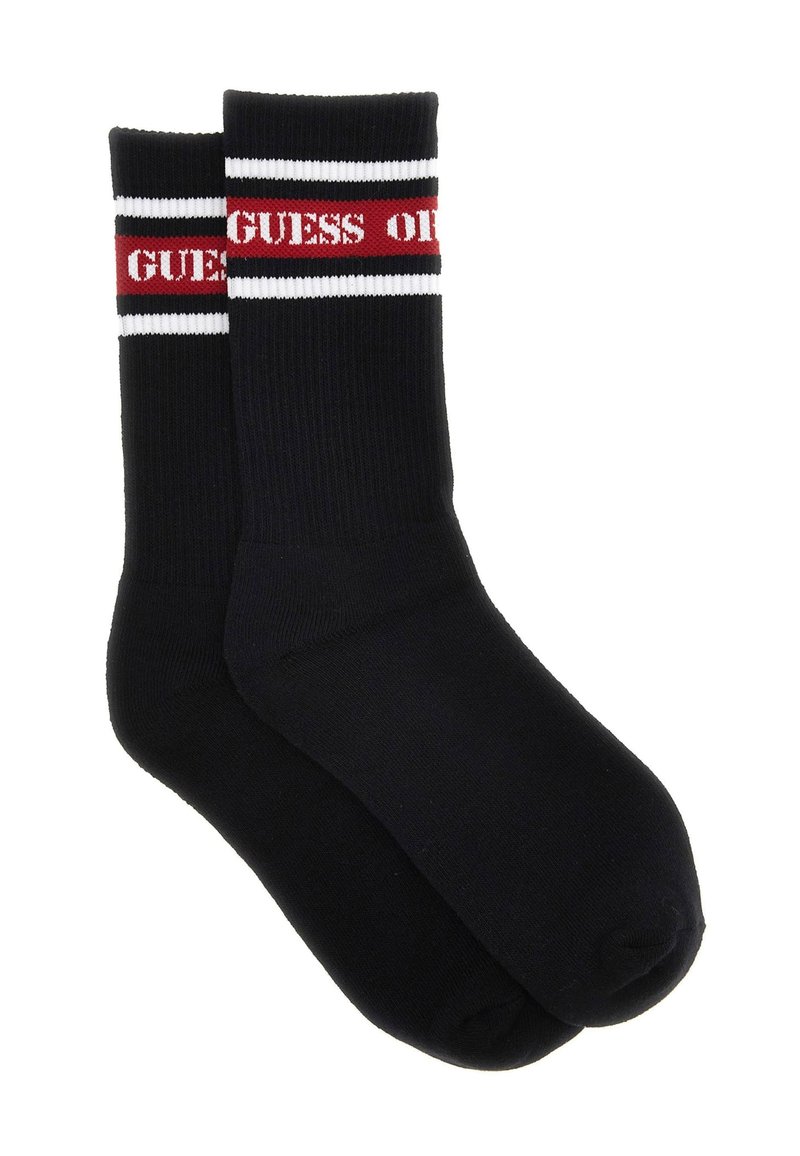 Calzini neri con texture a coste e una fascia rossa e bianca in cima, con la scritta "GUESS" in rosso.