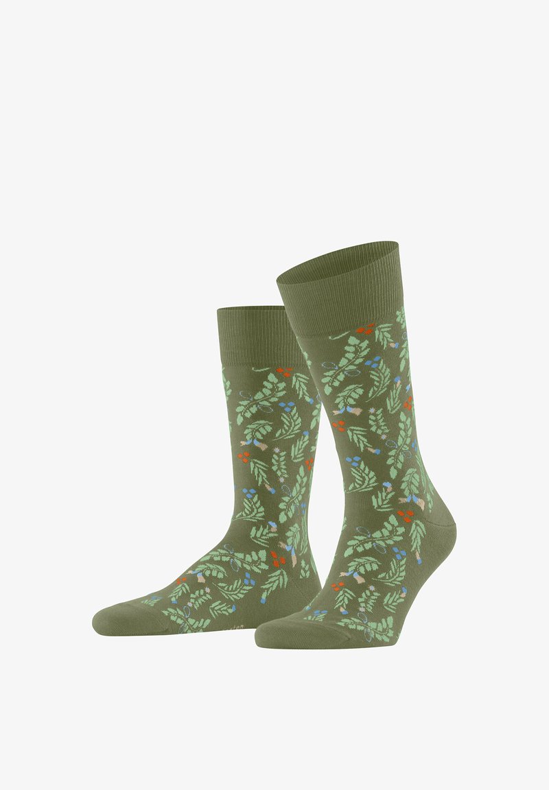 Chaussettes vertes à hauteur de cheville avec un motif botanique coloré composé de feuilles et de petites baies rouges, bleues et beiges dispersées partout.