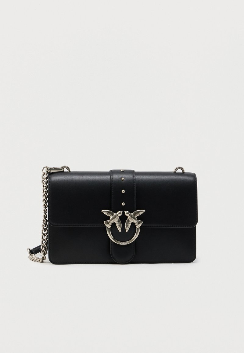 Μαύρη δερμάτινη τσάντα χειρός με μαγνητικό κλείσιμο με φτερό, ασημένιο διακοσμητικό πουλί, λουράκι αλυσίδα και διακοσμητικές μεταλλικές τρουκς στο μπροστινό μέρος.