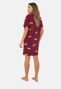 Bordowa bawełniana koszula nocna z krótkimi rękawami i żółtymi wzorami w muszki, o luźnym kroju i długości do połowy uda.