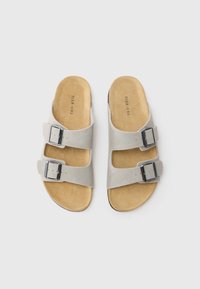 Sandale gri din suede cu două catarame ajustabile, talpă texturată și o talpă netedă neagră. Logo-ul brandului notabil imprimat în interior.