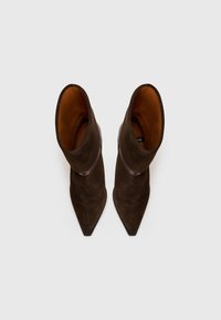 Brown suede high-heeled ankle boots with pointed toes, featuring a folded cuff and a smooth inner lining in a contrasting warm hue.