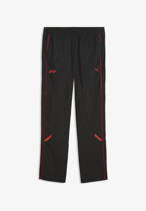 Pantaloni sportivi neri con un motivo a griglia sottile, loghi Puma e F1 rossi, piping laterale rosso, vita elastica e accenti rossi inclinati vicino alle ginocchia.