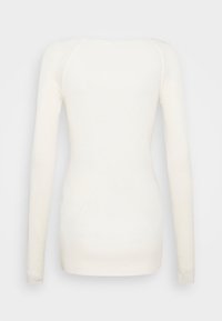 Langärmliges Oberteil aus weichem, cremefarbenem Stoff. Es verfügt über einen gerundeten Ausschnitt und eine figurbetonte Silhouette, mit einer glatten Textur und minimalen Nähten.