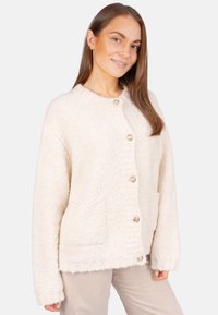 Cremefarbener Strickcardigan mit strukturiertem Stoff, rundem Ausschnitt, Fronttaschen und dekorativen Knöpfen. Lockerer Schnitt mit langen Ärmeln.