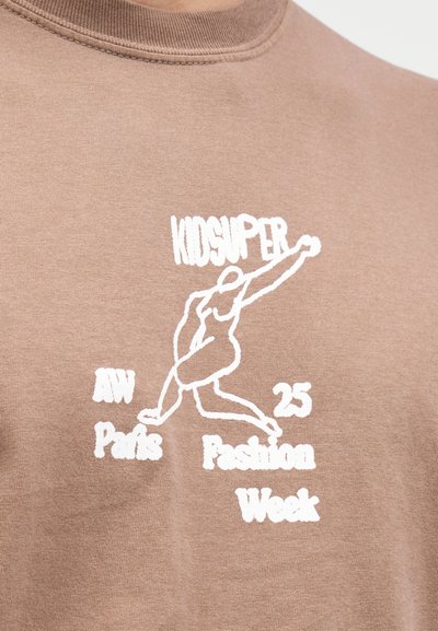 Καφέ φούτερ με λευκό γραφικό κείμενο και μια εικονογράφηση μιας κινούμενης φιγούρας. Μαλακό ύφασμα, στρογγυλή λαιμόκοψη, casual σχεδίαση.