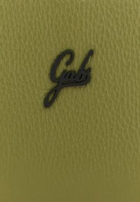 Superficie in pelle verde con finitura testurizzata caratterizzata da un logo in corsivo nero "Gabs." Aspetto liscio e leggermente lucido.