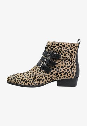 Botines tobilleros de estampado de leopardo con una parte superior texturizada en tono arena y detalles en cuero negro, además de tres hebillas negras. Punta redondeada y tacón bajo tipo bloque.