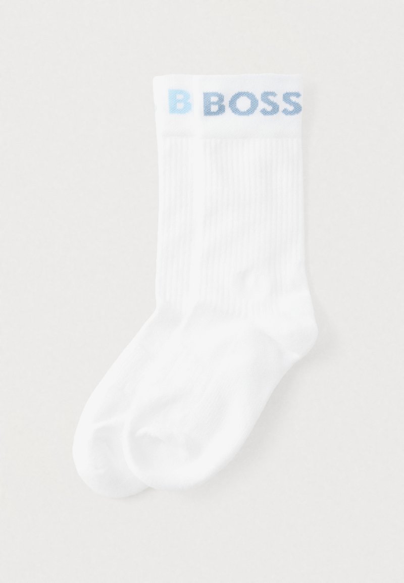 Białe skarpety z prążkowaną teksturą i jasnoniebieskim logo "B BOSS" na mankiecie. Standardowy sportowy design z zaokrąglonym noskiem.