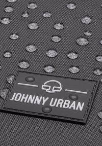 Black fabric with water droplets, featuring a rectangular rubber label embossed with "JOHNNY URBAN" and a logo design.