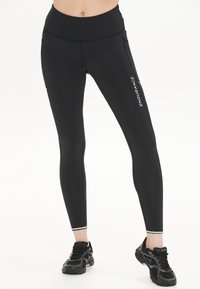 Mustat korkeavyötäröiset leggingsit, jotka on valmistettu joustavasta kankaasta. Niissä on sivutasku ja valkoinen "ENDURANCE" -logo jalan varrella.