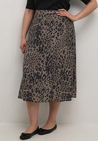 Leopard-print skirt in taupe with a flowing A-line design, featuring a soft texture and a comfortable waistband, paired with black flats.