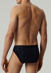 Czarne majtki o gładkiej teksturze, z delikatnym wzorem w pionowe zielone i niebieskie linie. Elastyczny pas dla komfortu.