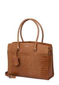 Sac à main en cuir tan présentant un motif crocodile texturé et des sections lisses, avec des poignées doubles et une étiquette amovible portant la marque.