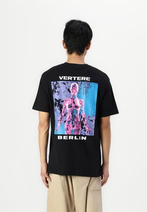 Black cotton t-shirt featuring a colorful graphic of a stylized figure, with the text "VERTERE" and "BERLIN" displayed prominently.
