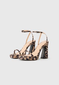 Sandale cu toc înalt cu imprimeu leopard, cu un design cu platformă, tocuri groase negre și bretele subțiri la gleznă. Fabricate dintr-un material moale din suede.