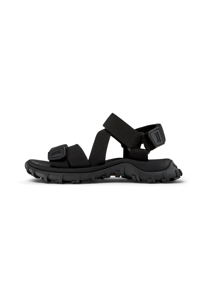 Svarte utendørs sandaler med tykke gummisåler, justerbare stoffremmer og en teksturert overflate; designet for komfort og holdbarhet.