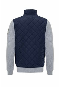 Gepolsterte marineblaue Stoffweste mit grauen langen Ärmeln; verfügt über einen hohen Kragen und ein rundes Logo auf der linken Schulter. Die glatte Textur bildet einen Kontrast zur Steppung.