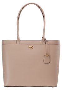 Sac cabas en cuir beige avec deux poignées, logo MK doré au centre et étiquette en cuir assortie suspendue à la poignée droite.