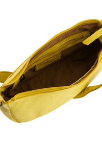 Gul læder håndtaske med en glat tekstur, lynlås lukning og brun indvendig foring. Har indvendige lommer til organisering.