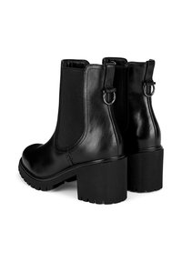 Čierne chelsea čižmy s elastickými bočnými panelmi, okrúhlym špičkou, lesklým povrchom a blokovým podpätkom s výškou 5 cm. Obsahujú oblé kovové akcenty na podpätkoch.