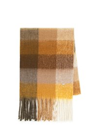 Szalik w kratę w ciepłych odcieniach żółci, brązu i szarości. Miękka tekstura z frędzlami na krawędziach oraz małą metką marki na jednej stronie.