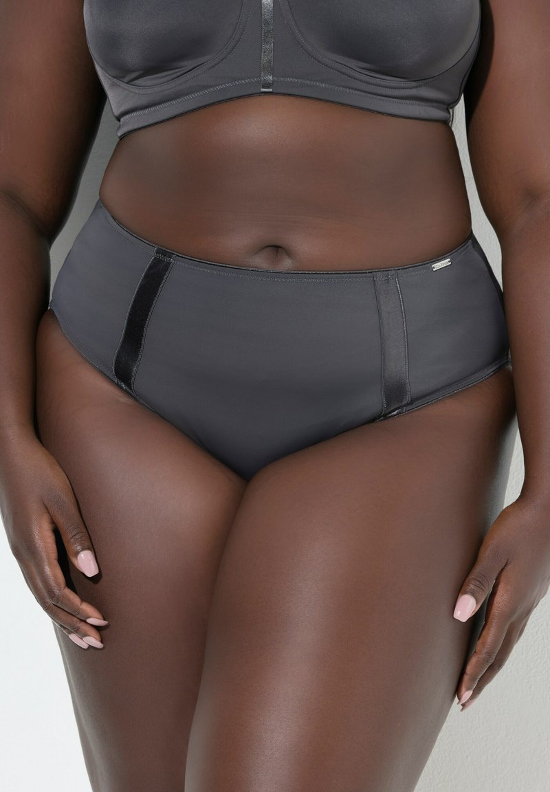 Wysokowysokie czarne majtki wykonane z gładkiego materiału, charakteryzujące się eleganckim designem, kontrastującymi bocznymi panelami oraz małym logo.