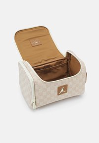 Kosmetiktasche in Beige mit Logo und bedrucktem Stoff. Verfügt über ein braunes Innenfutter, einen Reißverschluss und eine Netztasche zur besseren Organisation.