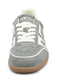 Sneaker grigio con una parte superiore testurizzata e pelosa, lacci bianchi, strisce bianche a contrasto e suola in gomma color cuoio.