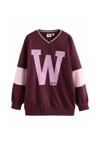 Bordeauxfärgad sweatshirt med V-ringning, med ett stort rosa "W" fram och rosa randiga detaljer på ärmarna. Mjuk tygkvalitet och avslappnad passform.