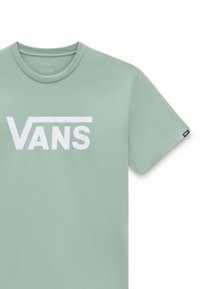 T-shirt Vans vert clair avec logo Vans blanc sur la poitrine et une petite étiquette Vans noire sur la manche droite.
